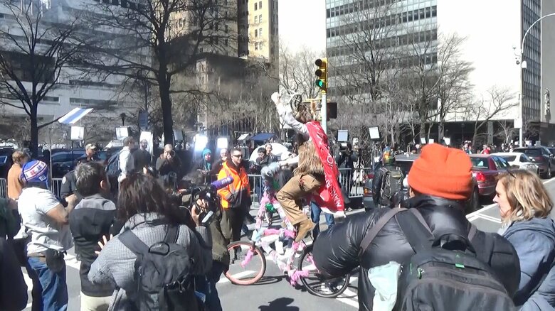 羊の格好をしたトランプ支持者の男性は自転車に乗りメディアにアピール