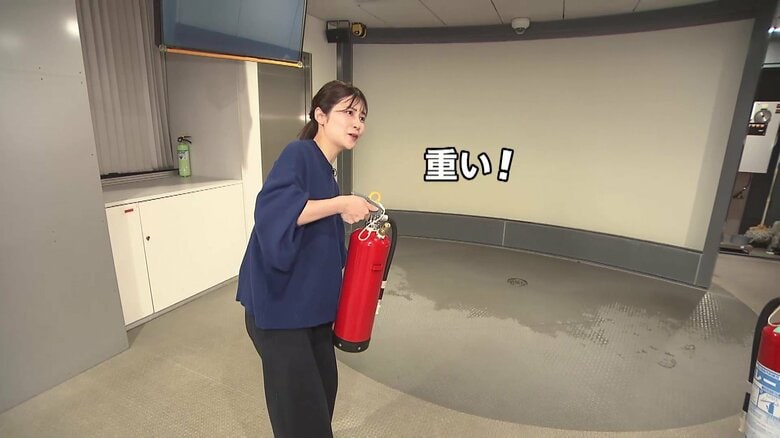消火器の使い方を体験する竹内友佳アナウンサー