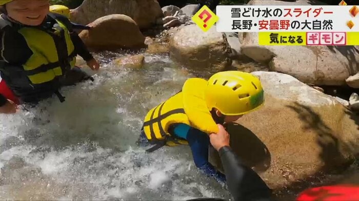 腰まで水に浸かって川を上る参加者