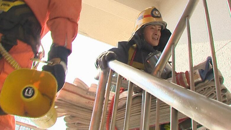 4階まで機材を運ぶ板垣消防士