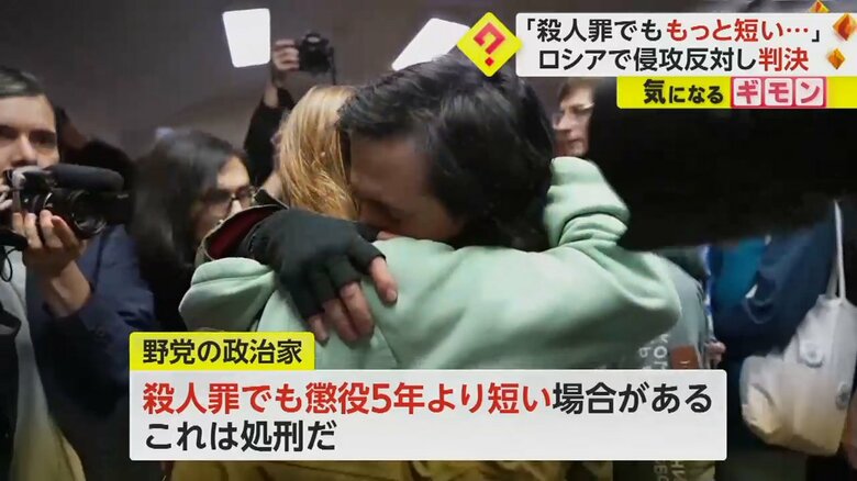 その場にいた人物と抱き合う、女性芸術家