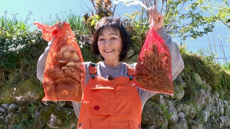 収穫したシイタケを持ち笑顔の財前さん