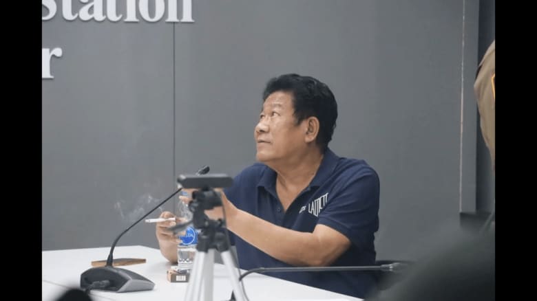 事情聴取中にタバコを吸う元国会議員の容疑者