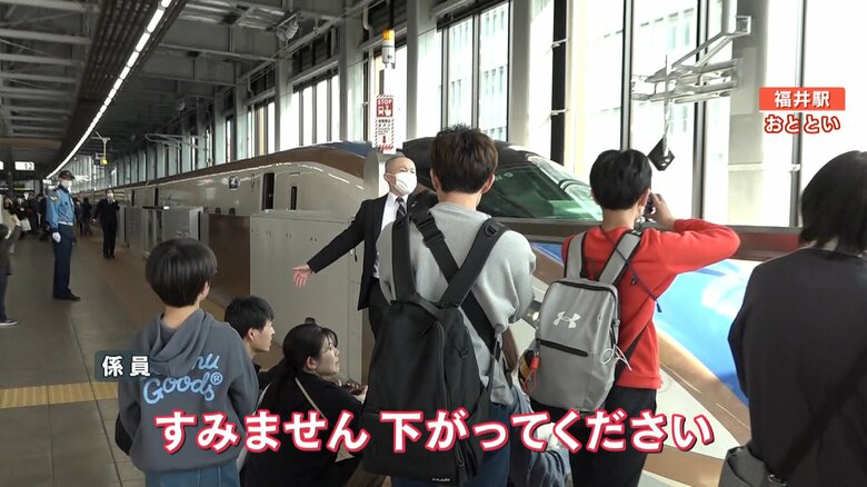 （撮影する人たちに注意する係員）