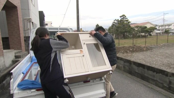 卒業生が不要になった家具をトラックに乗せる学生たち