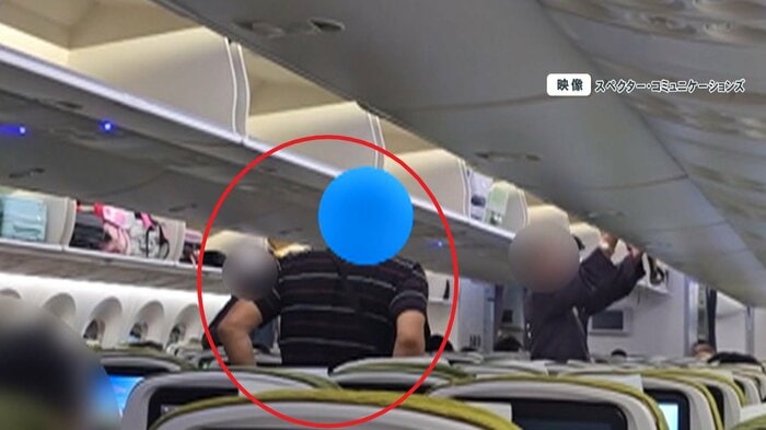 機内でおもむろに立ち上がる男