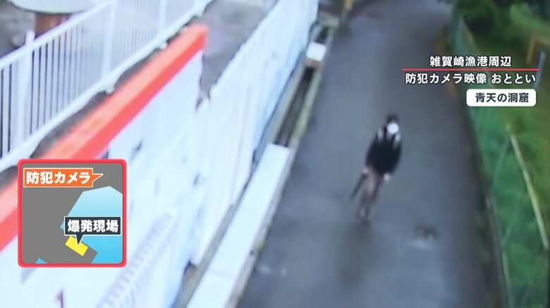 傘を持ってリュックを背負い、坂道を下る