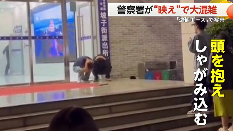 中国・湖南省の警察署の前で、まるで「逮捕されたようなポーズ」で記念撮影する人