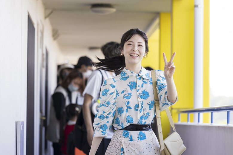 カメラに向かって笑顔でピース