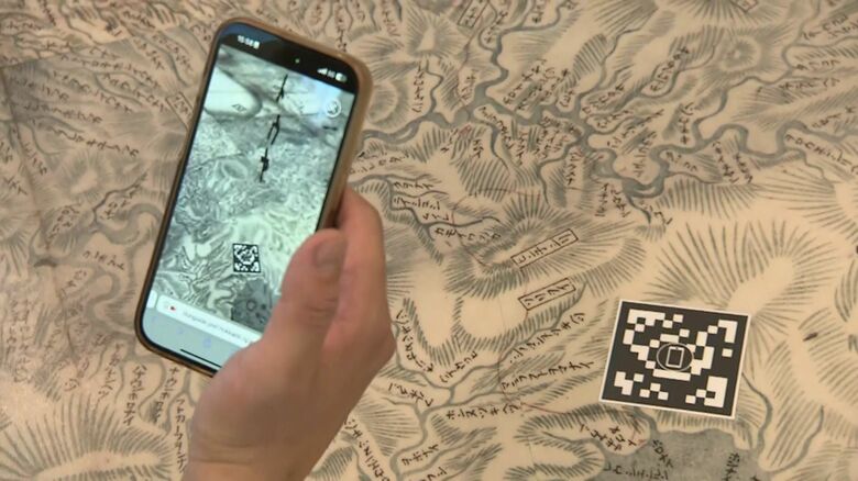 足元のQRコードを読み込む様子