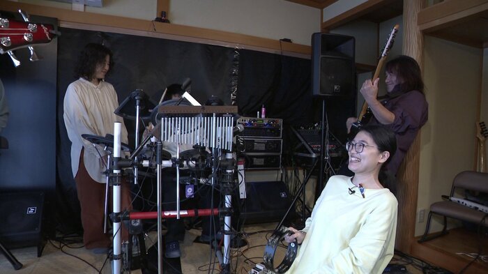 音楽プログラムで「自分の思いを伝える力を培ってもらいたい」と話す佐久間さん（手前）