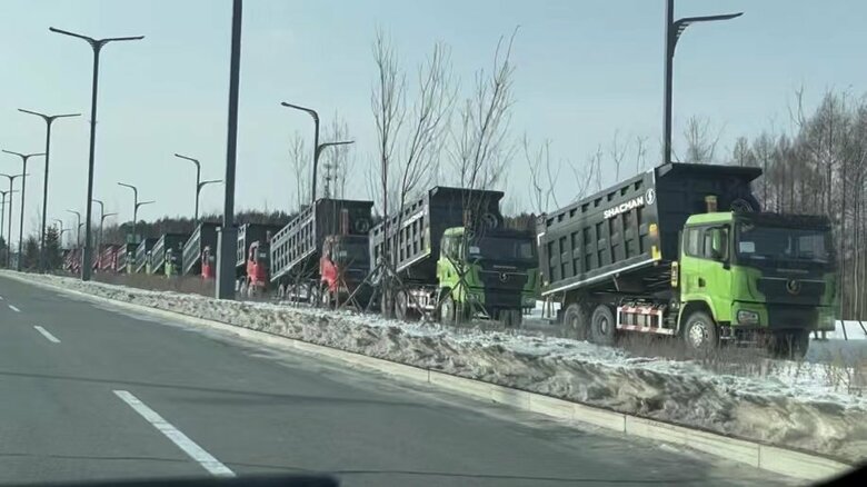 国境橋のたもとに並ぶ“新品の中国製トラック”