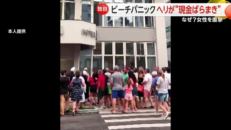 ホテルの窓からばらまかれたお金を拾う人々