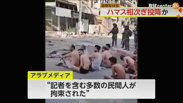 町中の路上に下着姿で座って並ばされているパレスチナ人と見られる男性たち