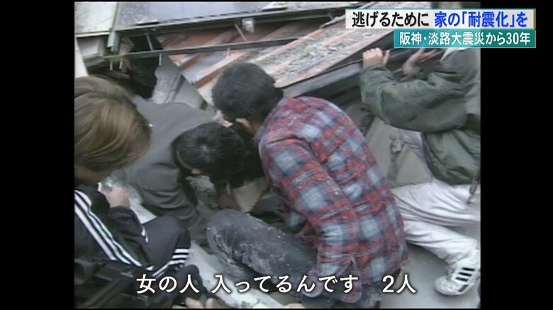 倒壊した建物の下にいる女性を救助しようとする人々