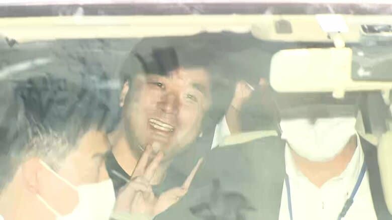 笑顔でピースサインを見せ警視庁に入るつばさの党代表・黒川容疑者　5月17日