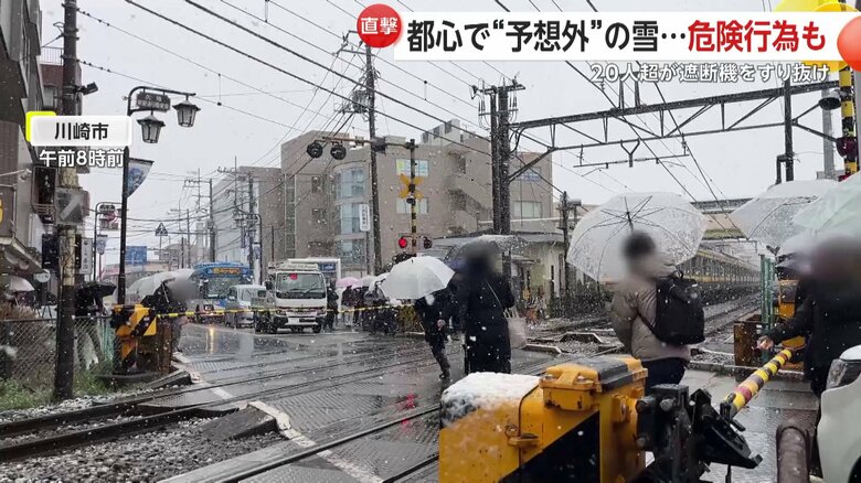 警報音が鳴る中、遮断機をすり抜け、20人以上が踏み切りを横断