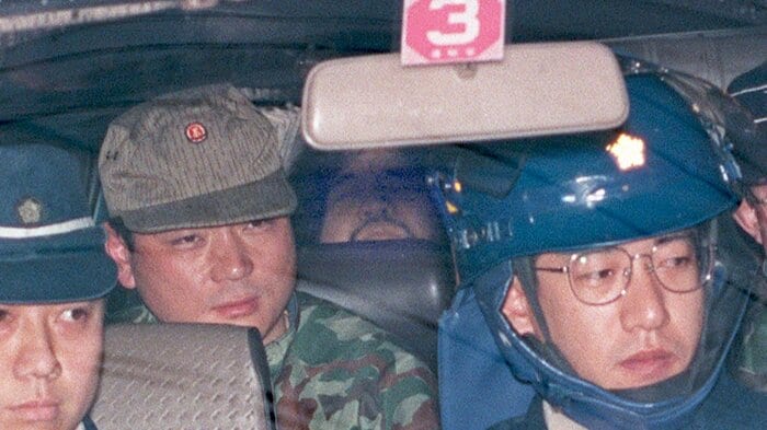 麻原元死刑囚を連行する牛島氏(迷彩服)