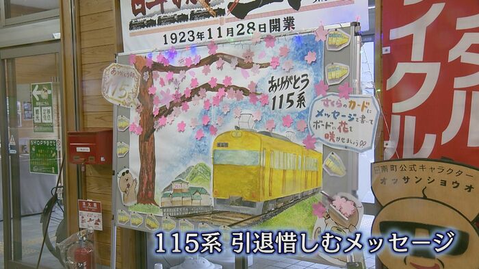 黄色い115系のイラストと桜の花を描いたメッセージボード