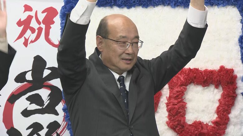 初当選を果たし支援者とバンザイする上坂さん（12日）