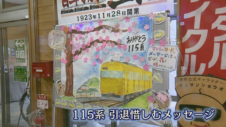 黄色い115系のイラストと桜の花を描いたメッセージボード