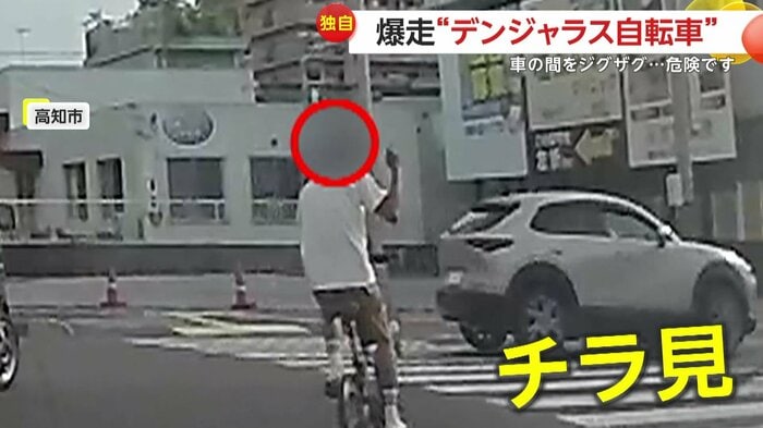 撮影者に向けて中指を立てる自転車の男性(視聴者提供)