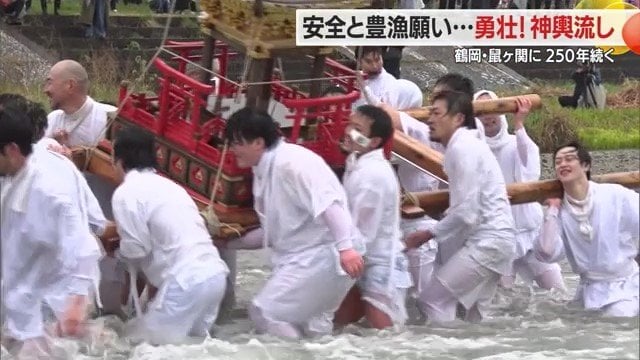 雪解け水で冷たい鼠ヶ関川でみこしを清める精進徒(しょうじんと)たち