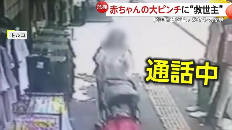 赤ちゃんを乗せたベビーカーを押す誰かと通話中の母親（トルコ）