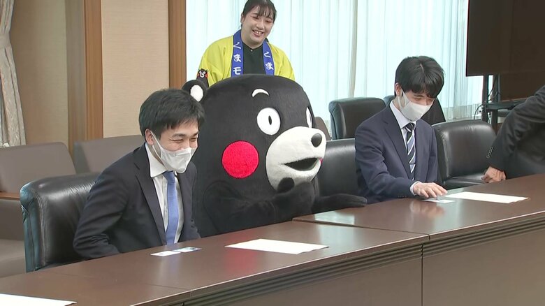 藤井七冠と菅井八段の間に座り込むくまモン