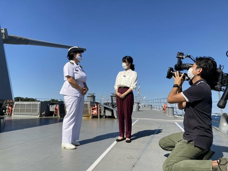 護衛艦「てるづき」の甲板を案内する小野小百合１佐（左）