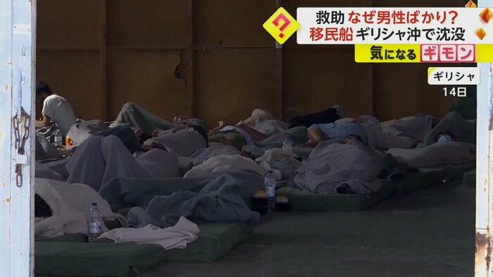 毛布にくるまって休む移民たち