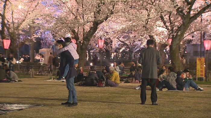 夜桜とともに飲食を楽しむ人たち