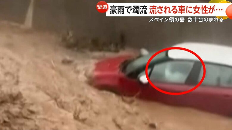 濁流の中に取り残された車に閉じ込められた女性