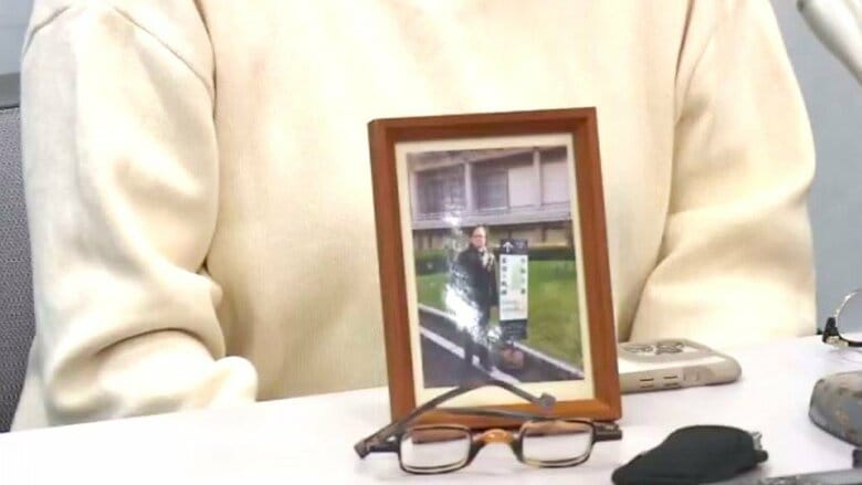 赤木さんの写真と取材に応じる妻・雅子さん