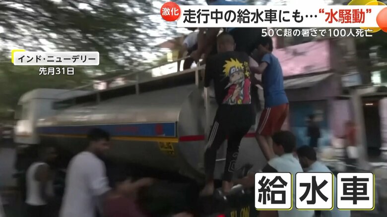 走行中の給水車に飛び乗る子どもたち