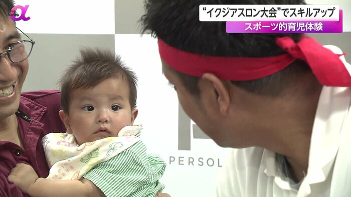 おむつ替えするパパを見守る赤ちゃん
