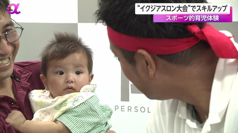 おむつ替えするパパを見守る赤ちゃん