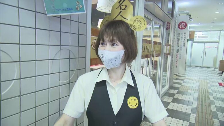紅白餅を配布していた女性。頭には名人をお祝いする飾りが