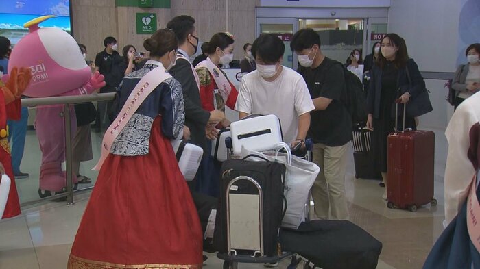 韓国の伝統衣装での出迎えを受ける乗客ら(金浦空港・6月29日)