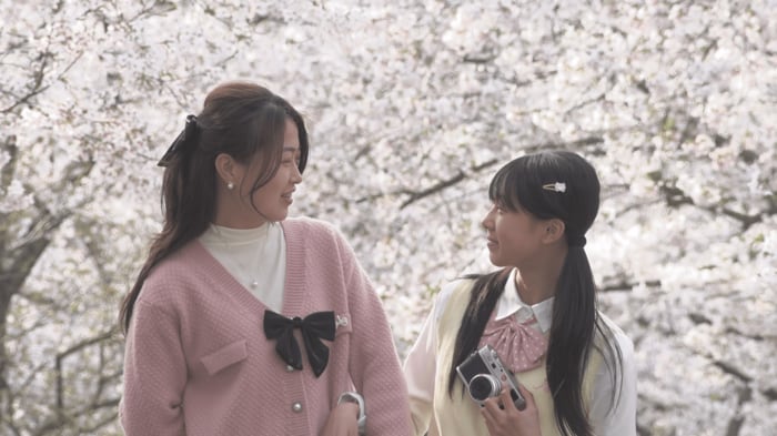 満開の桜を背景に記念撮影する親子（撮影：工藤雄矢）