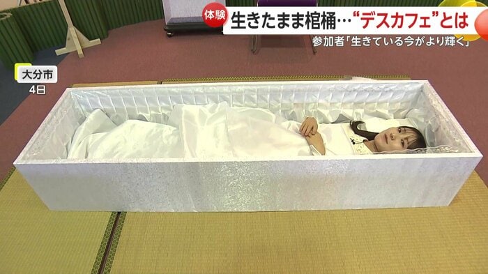 棺に入って横たわる取材アナウンサー