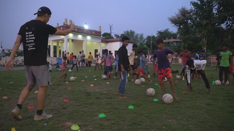 子どもたちにサッカーを教える萩原さん