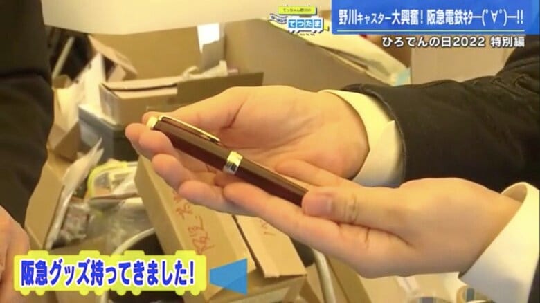 持参した阪急電車グッズを館長に見せる野川アナ