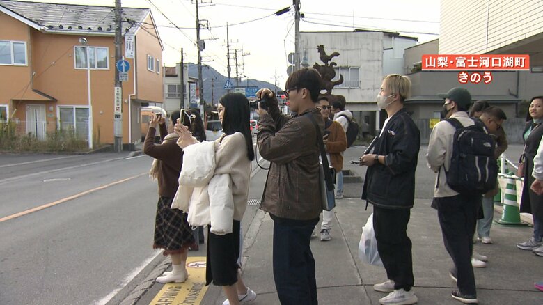 何かに向かってシャッターを切る外国人観光客ら