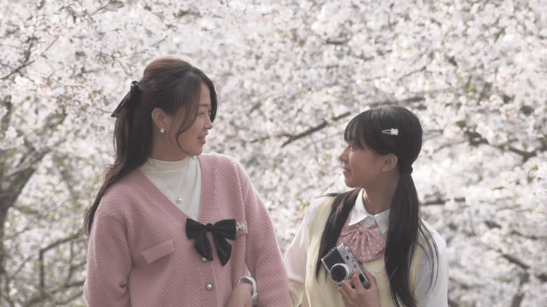 満開の桜を背景に記念撮影する親子（撮影：工藤雄矢）