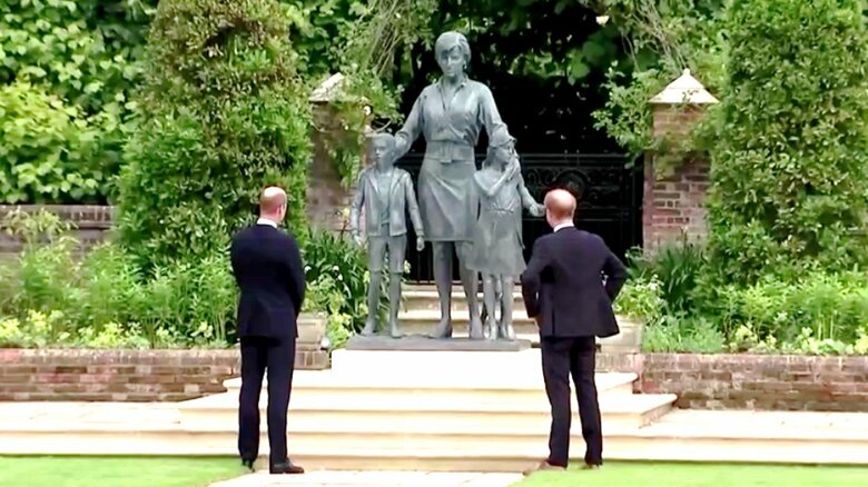 母ダイアナ妃の像をじっと見つめるウイリアム王子（左）とヘンリー王子（右）