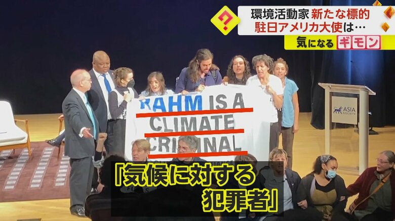 「気候に対する犯罪者」と書かれた横断幕を掲げた
