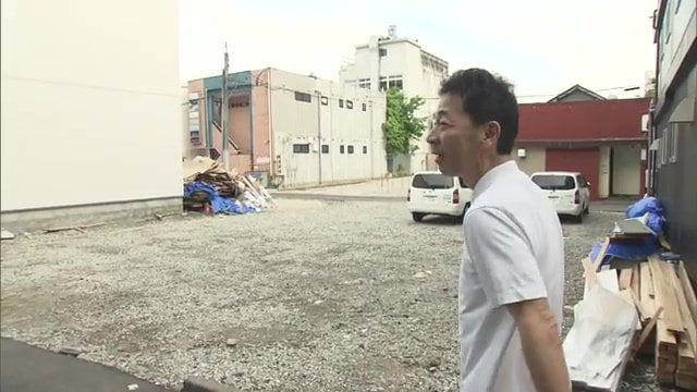 かつて店があった場所を案内する鈴木彰浩さん