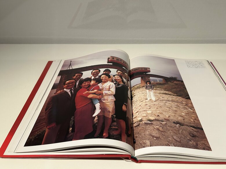 写真左側に集まった同級生から離れて立つ横尾氏