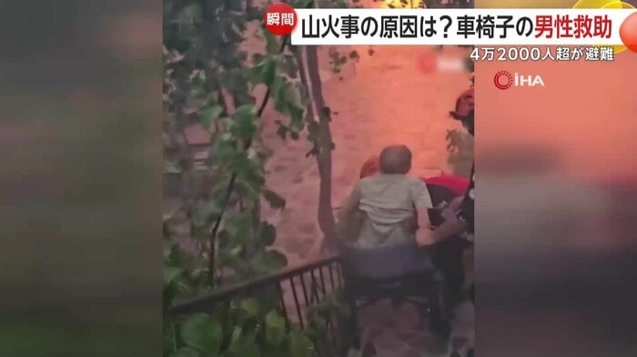 車椅子の男性を抱える救助隊員